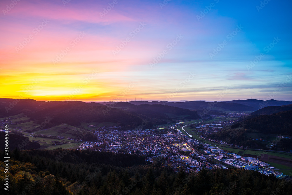 Germany, Magical sunset sky over black forest village haslach im kinzigtal houses,streets,cityscape illuminated by night, aerial view from above with colorful unreal red sky,a perfect nature landscape