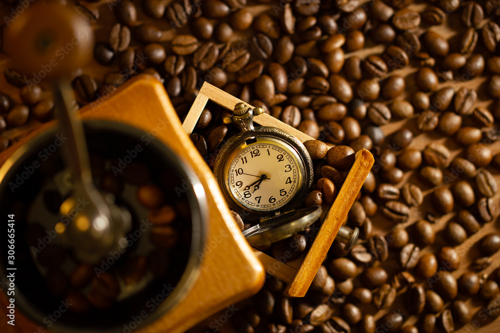 Coffee bean and pocket watch the tray of manual grinder on table. Top view and copy space. Concept of coffee time in morning. Coffee bean and pocket watch the tray of manual grinder on table. Top view and copy space. Concept of coffee time in morning.