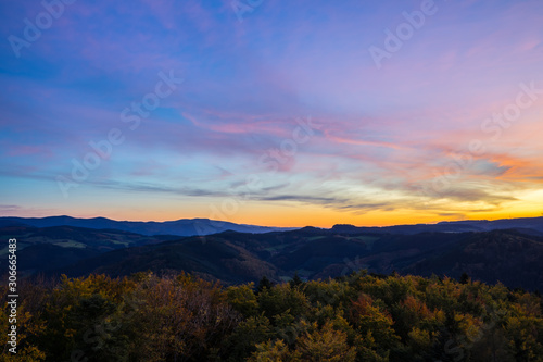 Germany, Aerial view above endless wide beautiful black forest holiday nature landscape above tree tops at sunset in autumn season
