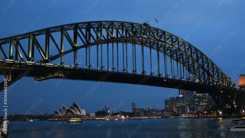 Zoom in to Circular Quay waterfront besides the Sydney Harbour bridge at sunset with bright illumination – Australian landmarks. Zoom in to Circular Quay waterfront besides the Sydney Harbour bridge at sunset with bright illumination – Australian landmarks.