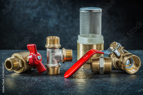 set of brass pipe connectors ondark background photo