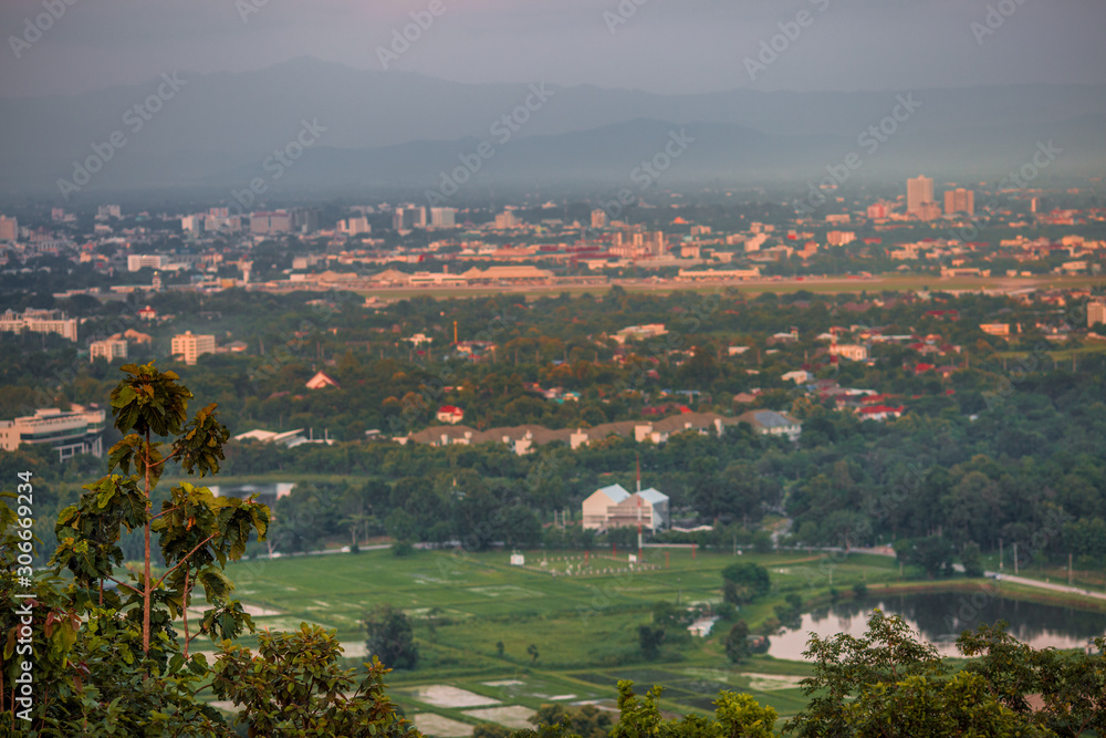 Naklejka premium Blurry high angle nature background, which can see distant views (houses, mountains, trees, roads). The atmosphere is surrounded by the wind blowing through, seen at the natural viewpoint on the way.
