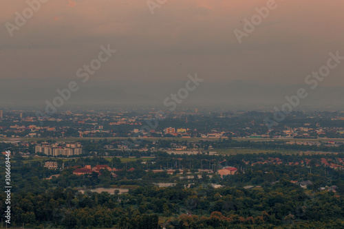 Blurry high angle nature background, which can see distant views (houses, mountains, trees, roads). The atmosphere is surrounded by the wind blowing through, seen at the natural viewpoint on the way. © bangprik