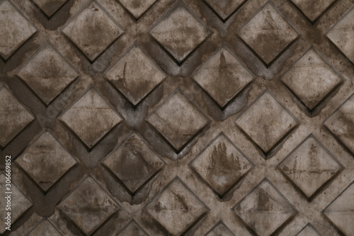 Texture of rhombus on the surface of a brown cement background with rust and smudges and scratches.