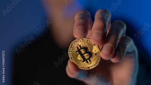 man holds cryptocurrency coin in his hands