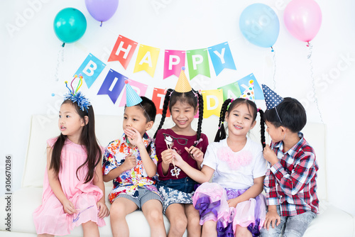 Adorable Asian schoolkids group with beautiful dresses enjoy the birthday party at home with many gift boxes   juices  and bakery
