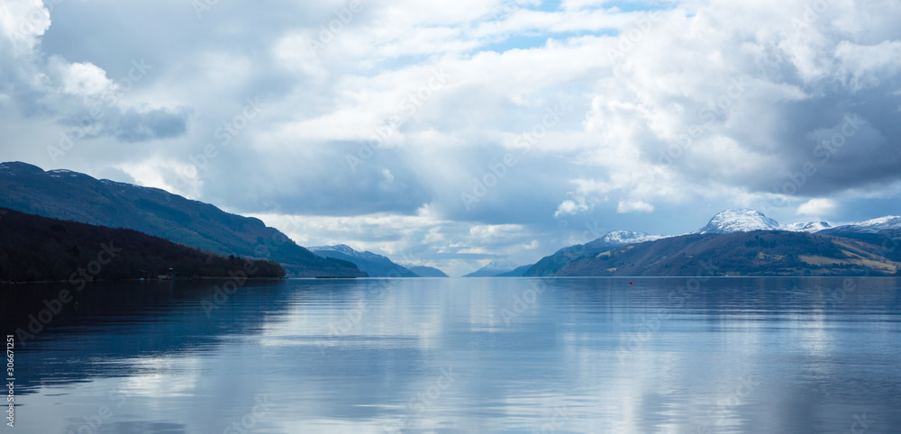 A view across Loch Ness looking down the length of the lake, with dark clouds above, in Scotland, UK