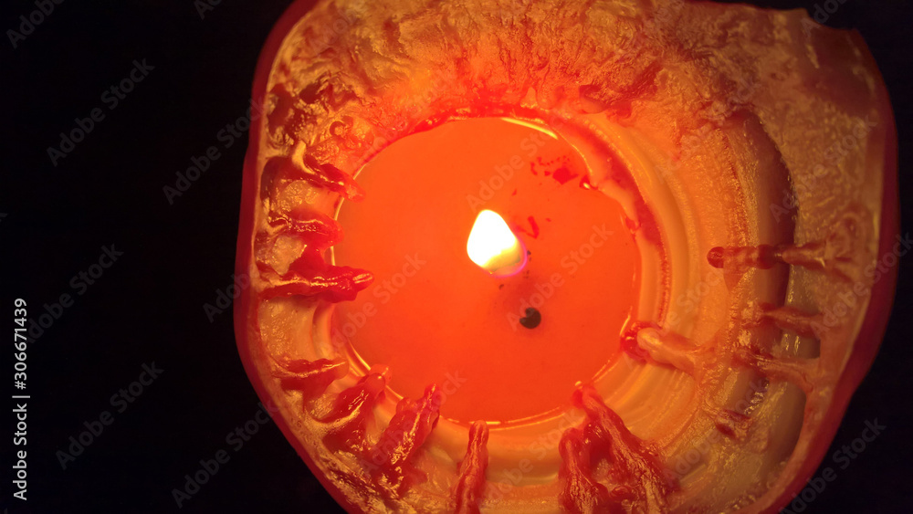 a red candle burns a wick and wax melts