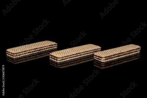 Group of three whole sweet chocolate biscuit wafer isolated on black glass