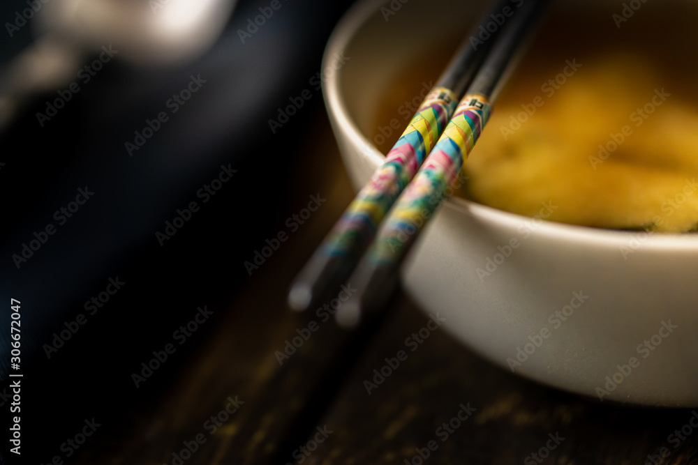 Naklejka premium Miso soup in a white bowl with chopsticks