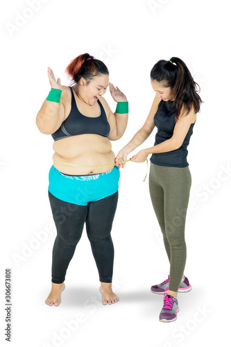 Woman measuring the fat belly of another woman