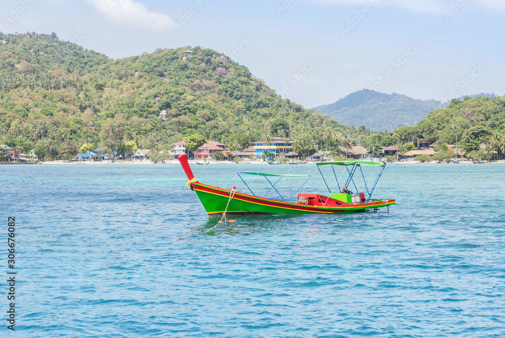 Colorful wooden longtail boat floating on tropical turquoise sea in thailand