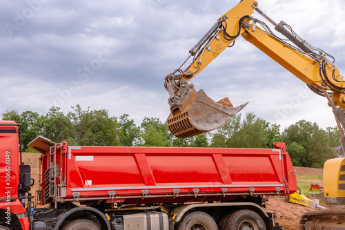 Bagger ladet Erde in den Kipper