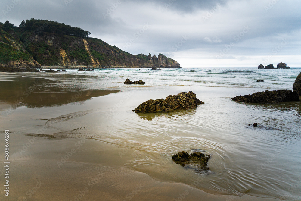 View of Playa del Aguilar at low tide at sunset in Asturias in Spain.