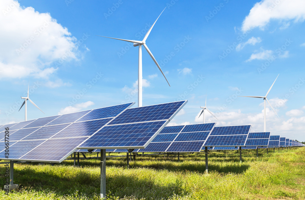 © Soonthorn - solar cells with wind turbines generating electricity in hybrid power plant systems station on blue sky background alternative renewable energy from nature  Ecology concept.