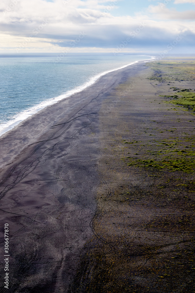 Vik, Iceland, coastline. Iceland black sand. Ocean and black sand coast. White waves. South Iceland landscape. Black, white, blue landscape.