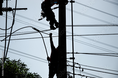 Technicians are repairing high voltage transmission systems on the power poles.