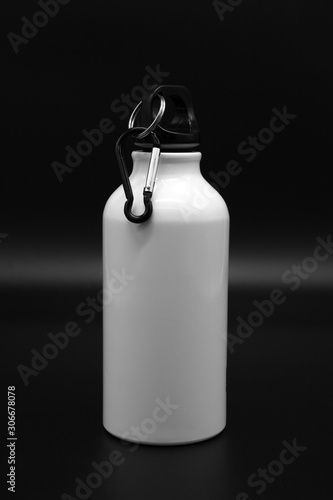 White travel flask with hook isolated on black background for attaching to a backpack