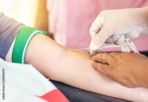 Nurse injecting needle syringe in to the arm to blood donor during transfusion blood donation unit in laboratory  the hospital.     