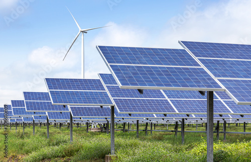 solar cells with wind turbines generating electricity in hybrid power plant systems station on blue sky background alternative renewable energy from nature  Ecology concept.   