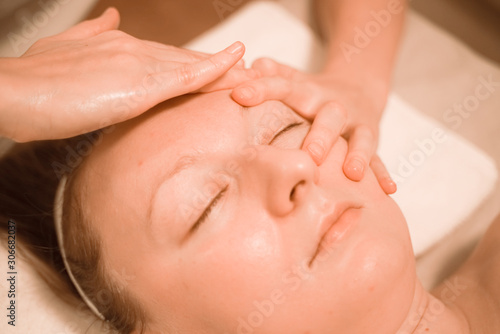 Beautiful plus size middle age woman getting a face massage treatment at beauty salon. close up step by step