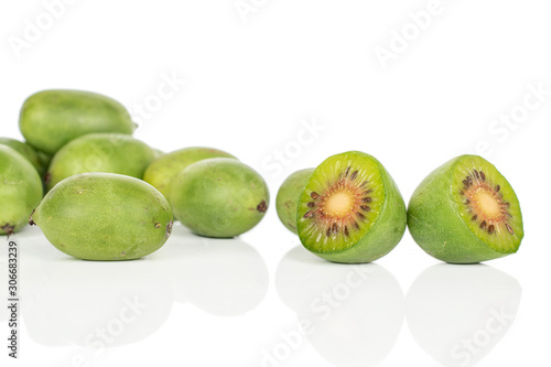 Group of eight whole two halves of hardy green kiwi isolated on white background