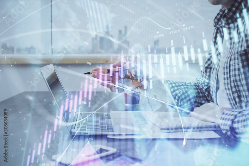 Double exposure of stock market chart with man working on computer on background. Concept of financial analysis. © peshkova
