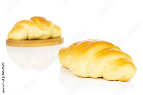 Group of two whole sweet golden mini croissant on bamboo coaster isolated on white background