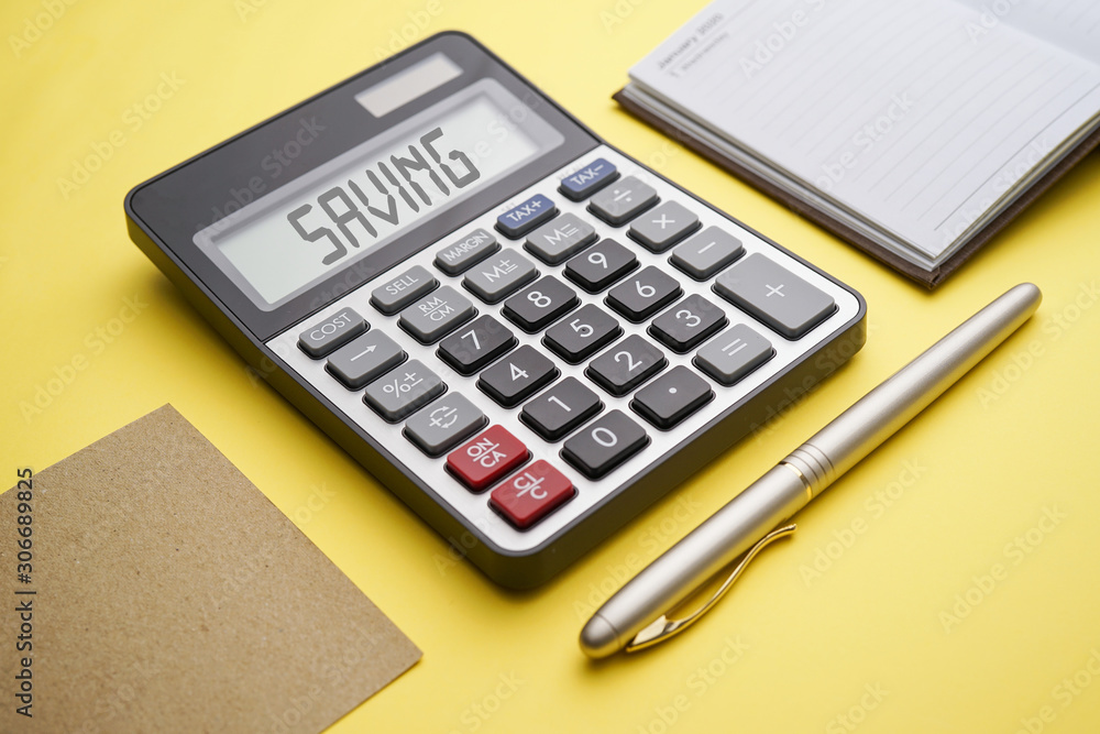 Calculator with text Saving. Calculator, currency, book, and gold pen on Yellow background. Business, finance conceptual. Calculator with text Saving. Calculator, currency, book, and gold pen on Yellow background. Business, finance conceptual.