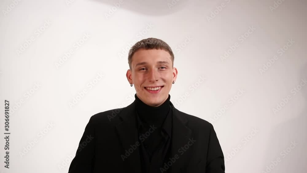 Man in black suit shrugging shoulders and smiling, white background Man in black suit shrugging shoulders and smiling, white background