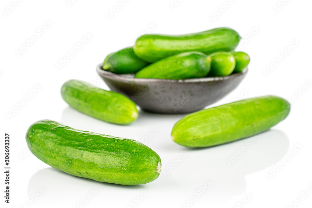Lot of whole fresh green baby cucumber in dark ceramic bowl isolated on white background Lot of whole fresh green baby cucumber in dark ceramic bowl isolated on white background