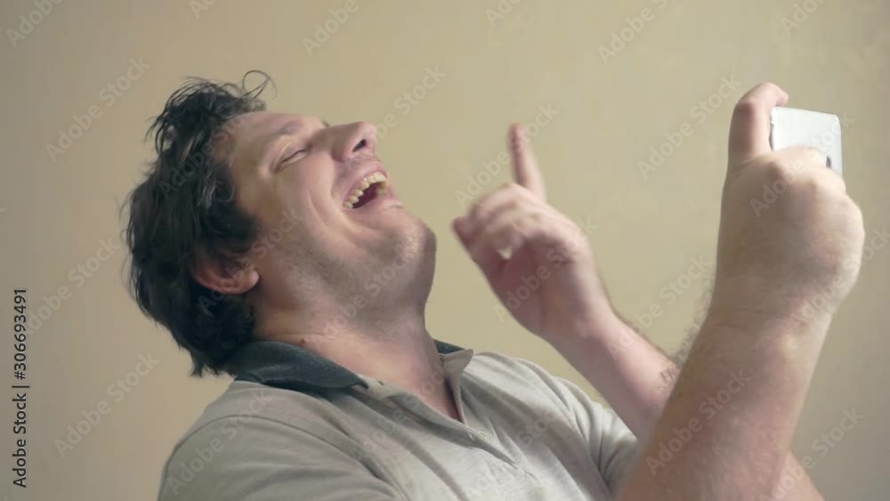 funny dude who looks in surprise at his smartphone.humorous portrait of a freak funny dude who looks in surprise at his smartphone.humorous portrait of a freak