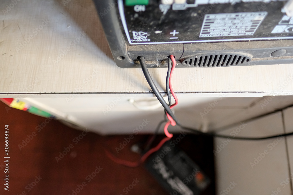 Shallow focus of Live and Neutral wires seen leaving a lead-acid battery charge. Used for charging farm tractor batteries during the cold weather. Shallow focus of Live and Neutral wires seen leaving a lead-acid battery charge. Used for charging farm tractor batteries during the cold weather.