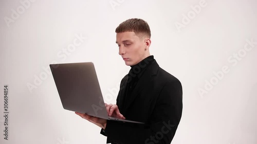 Man in a suit, a businessman uses a gray laptop on the white background