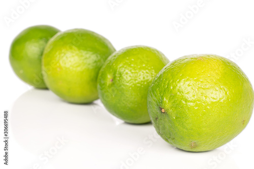 Group of four whole sour green lime diagonal isolated on white background