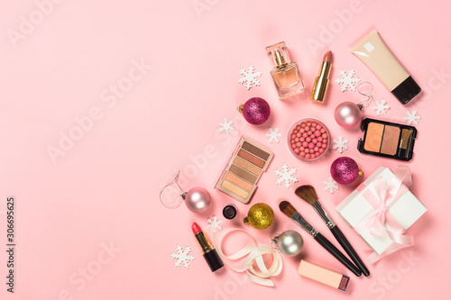 Makeup professional cosmetics with christmas decor on pink.