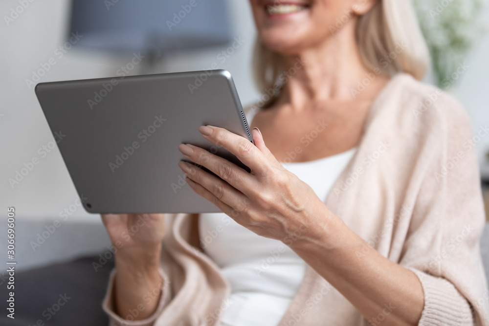 Smiling woman closeup selective focus on arms holding tablet device Smiling woman closeup selective focus on arms holding tablet device