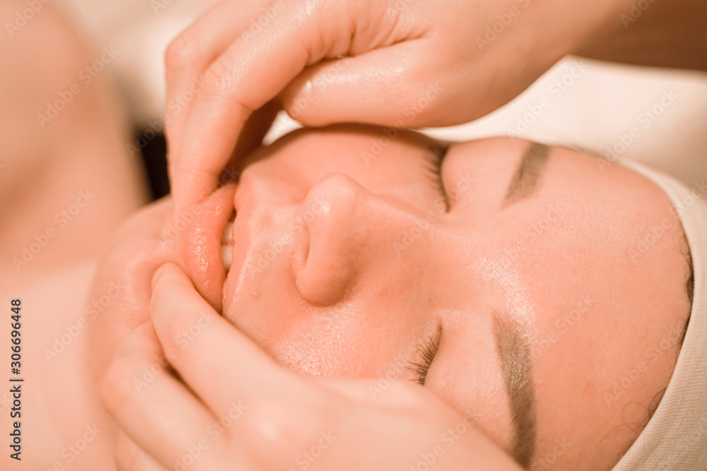 Beautiful young woman getting a face massage treatment at beauty salon Beautiful young woman getting a face massage treatment at beauty salon