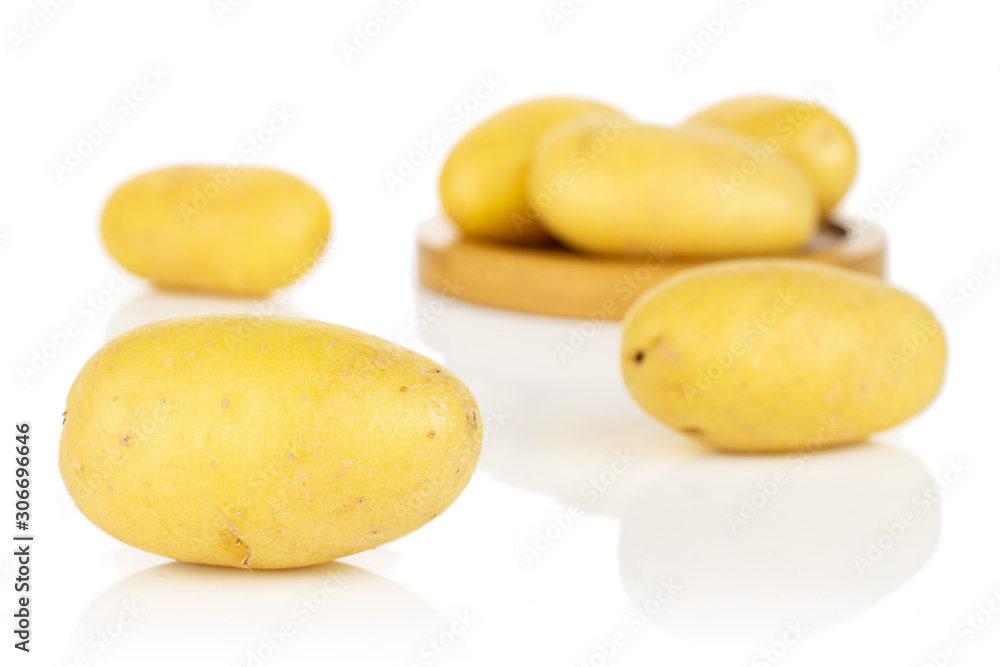 Group of six whole pale yellow potato on bamboo coaster isolated on white background Group of six whole pale yellow potato on bamboo coaster isolated on white background