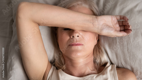 Foto Closeup melancholic woman lying put hand on face feels unwell