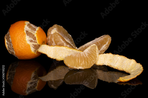 Group of one whole one half two pieces of fresh orange mandarin isolated on black glass