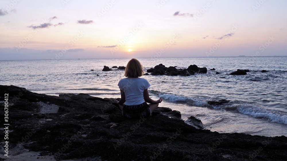 girl meditating practising yoga at the beach kimono thailand sunset