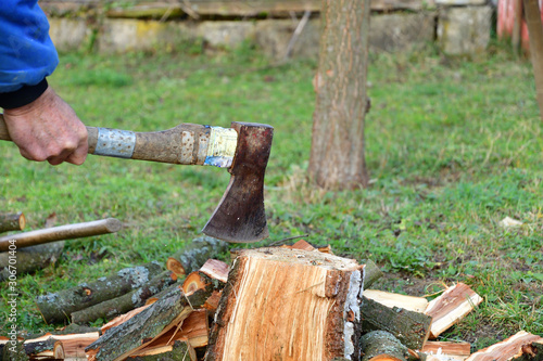 Detail on an ax as it cuts logs of wood into smaller pieces