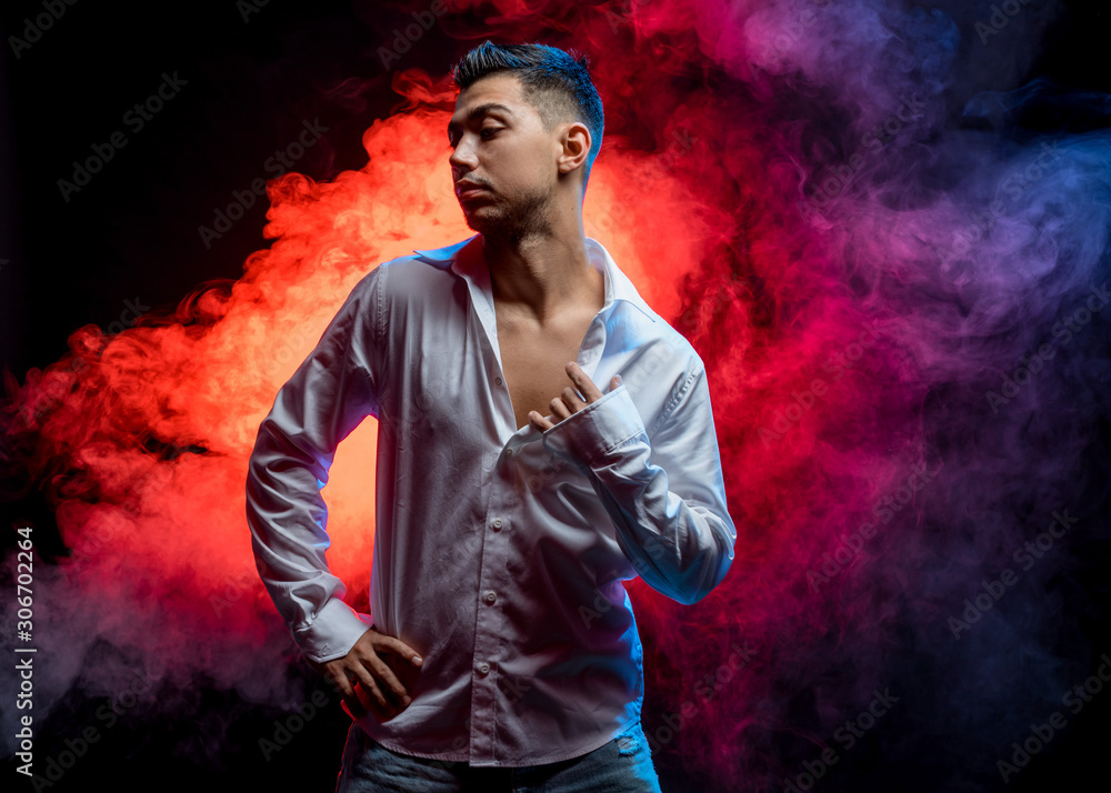 young caucasian man wearing casual wear posing isolated over smoky background. dance, leisure