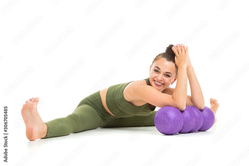 attractive brunette girl in a green sports suit goes in for sports with a simulator on a white background attractive brunette girl in a green sports suit goes in for sports with a simulator on a white background
