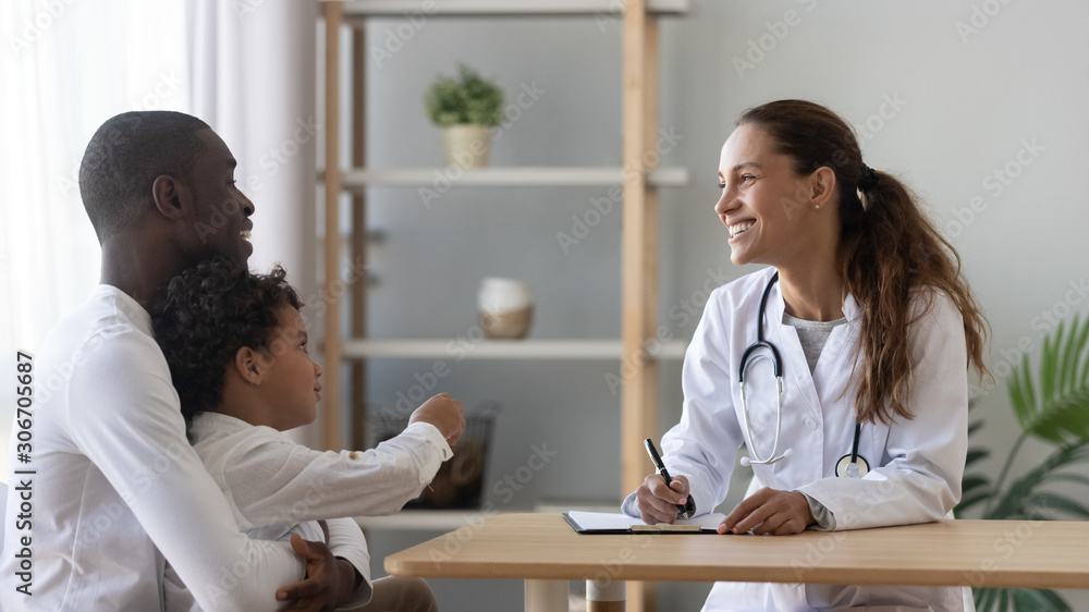 Happy african american man visiting friendly female pediatrician with son. - obrazy, fototapety, plakaty 