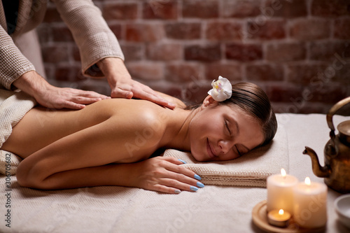 Attractive woman getting spa procedures, back massage by female hands lying on table. Spa, treatment, healthcare concept