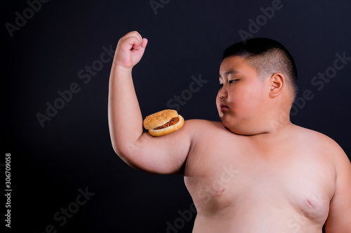 Fat boy wants to eat burgers that are placed on the biceps arms. photo