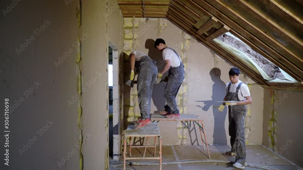 Plastering mortar machine. Automatic plaster. Repairing or renovating house or apartment. Builder at construction professional Plastering mortar machine. Automatic plaster. Repairing or renovating house or apartment. Builder at construction professional