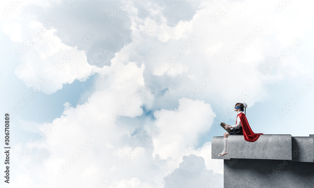 Girl power concept with cute kid guardian against cloudscape background . Mixed media Girl power concept with cute kid guardian against cloudscape background . Mixed media